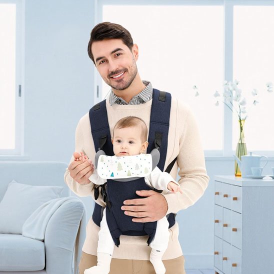 Porte bébé papa au salon avec son bébé