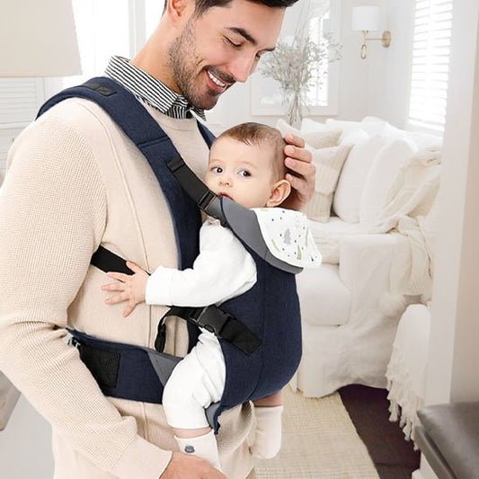 Porte bébé papa sourie avec son bebe